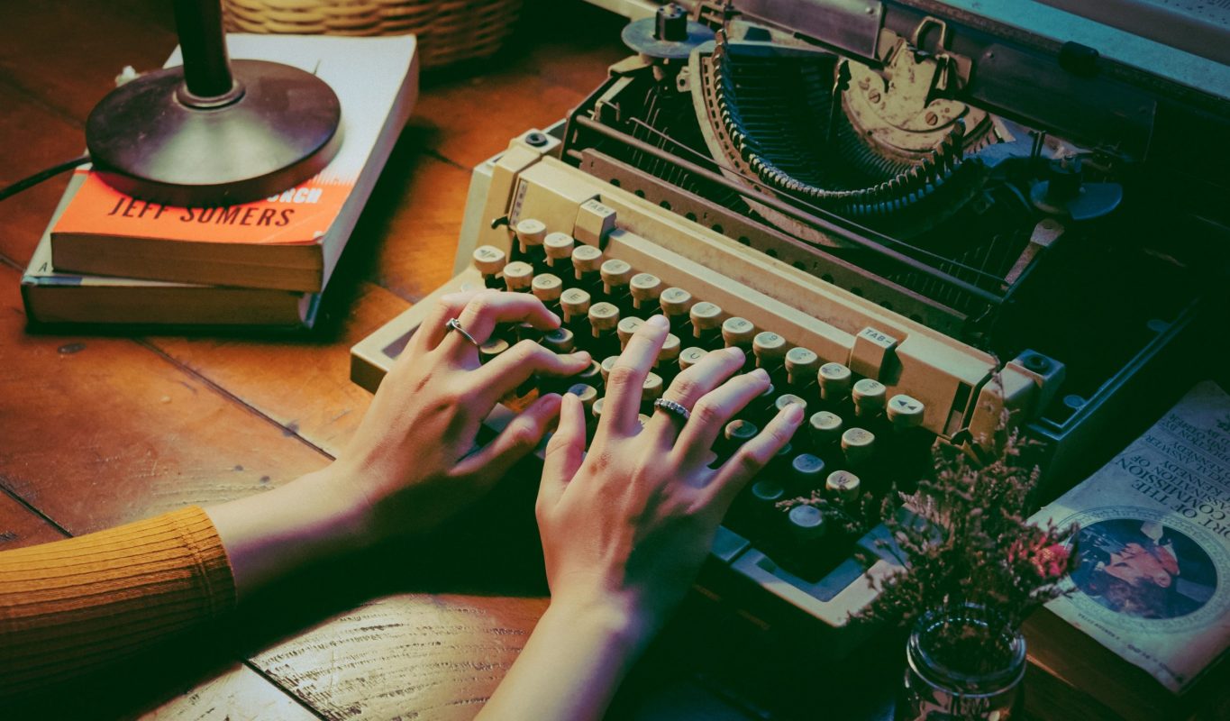 Jemand schreibt auf einer Schreibmaschine